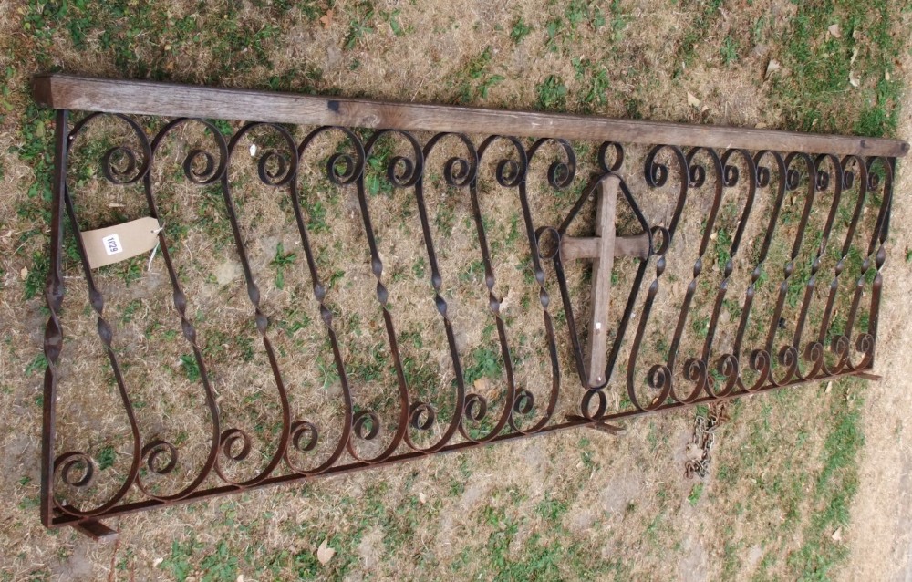 A reclaimed ecclesiastical run of railing with simple scroll work detail flanking a central wooden