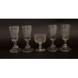 A set of four antique glass cordial glasses with broad bases and etched with monograms together with