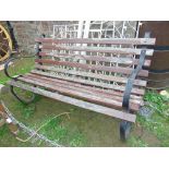 A garden bench with sprung steel frame and teak wood timber lathes