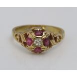 An 18ct pink ruby and diamond ring of quatrefoil form with scrolling shoulders, size N/O, 5g