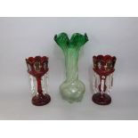 A pair of late 19th century cranberry glass lustres with prismatic drops; together with a further