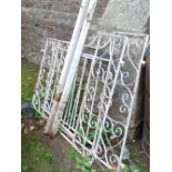 A pair of cream painted iron work driveway entrance gates with vertical partially twisted rails