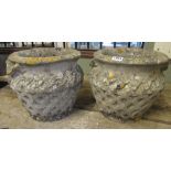 A pair of weathered reconstituted urns with repeating Celtic knot detail
