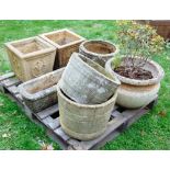 Seven contemporary weathered cast composition stone garden planters of varying design with relief