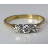 An 18ct three stone diamond ring, largest diamond 0.15cts approx, size M/N, 2.1g