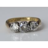 An 18ct gold and platinum three stone diamond ring, central stone 0.50cts flanked by two diamonds