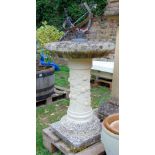 A partially weathered contemporary cast composition stone sun dial with trailing relief fruiting