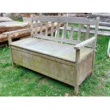 A teak wood garden bench by Firman, with box seat and rising lid providing storage