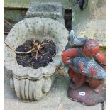 A weathered planter of shell form with scrolled detail