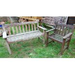A small weathered teak wood garden bench with stick back and matching single chair