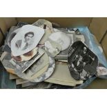 A box containing a mixed collection of black and white family pictures