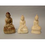 Three carved alabaster Buddhist figures, one with traces of painted details, 16cm high