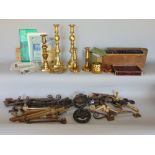 A box containing a collection of various metal ware, to include brass candlesticks, iron door