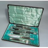 An early 20th century leather cased, horn handled carving set, comprising nine pieces of horn