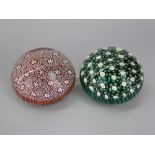Two similar glass paperweights, one a green colourway the other red, 10cm diameter (2)