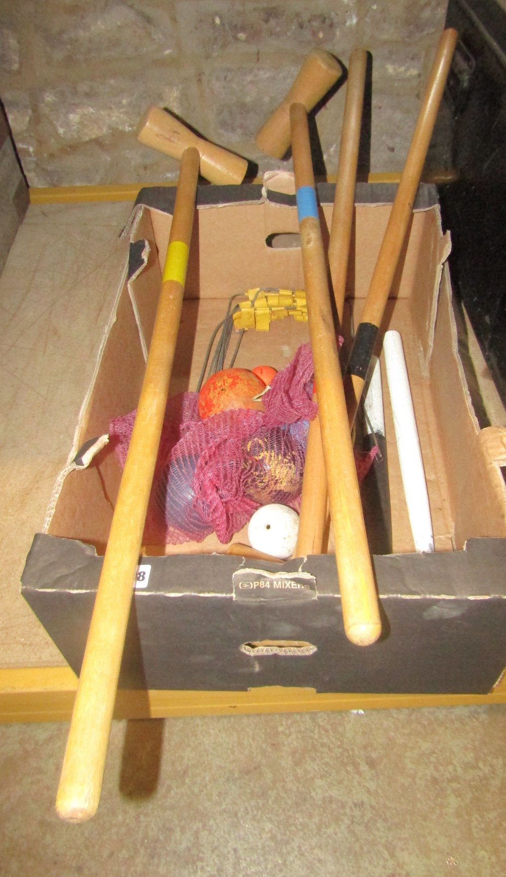 A contemporary croquet set comprising four beechwood mallets, seven simple wire hoops, various