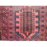 An eastern wool rug, principally in a red and blue colourway, within alternating borders, 135 x