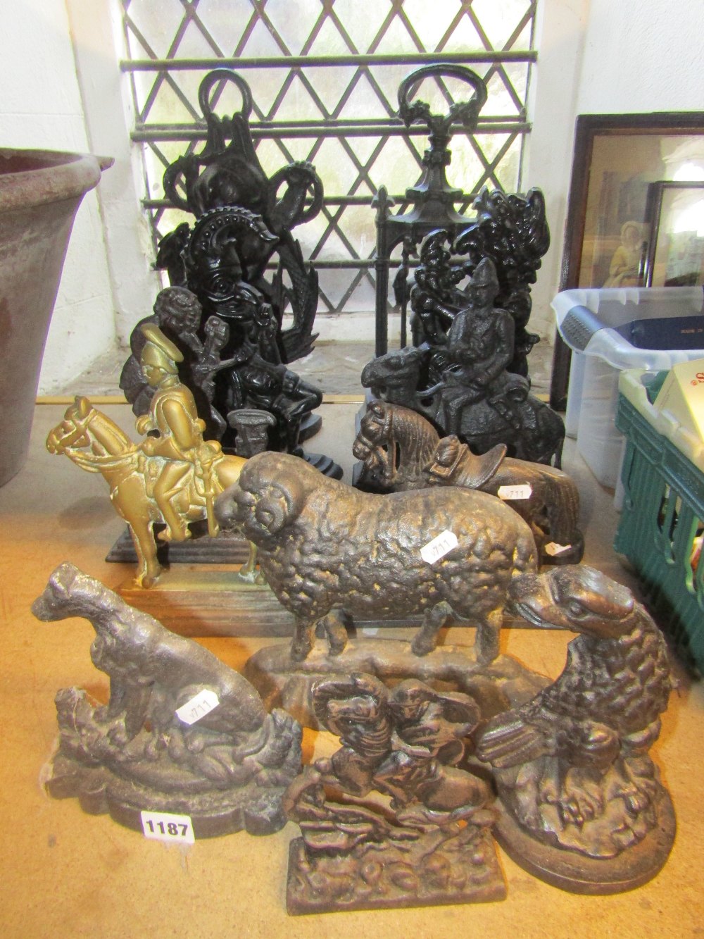 A collection of cast iron door porters to include examples in the form of Punch & Judy, cherub and