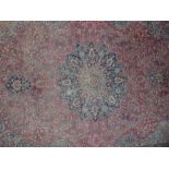 An old Persian rug, the central medallion with a floral theme, the red ground decorated with further