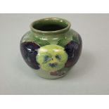 A small Moorcroft green ground vase of globular form with yellow, green and purple pansy