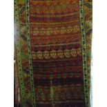 An old Persian wool runner, the central red ground field with repeating geometric borders and