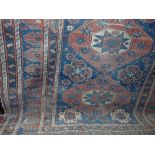 An old Persian rug with multi medallion centre upon an alternating red and blue ground field