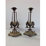 A pair of French pewter candlesticks, mounted by twin headed griffin's upon a lobed plateau, 29cm