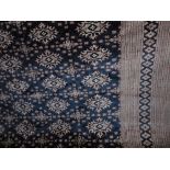 An eastern wool carpet with ink black field, with multi geometric panels, set within wide running