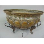 Venetian embossed brass brazier with steel liner, upon a stylised base decorated with three standing