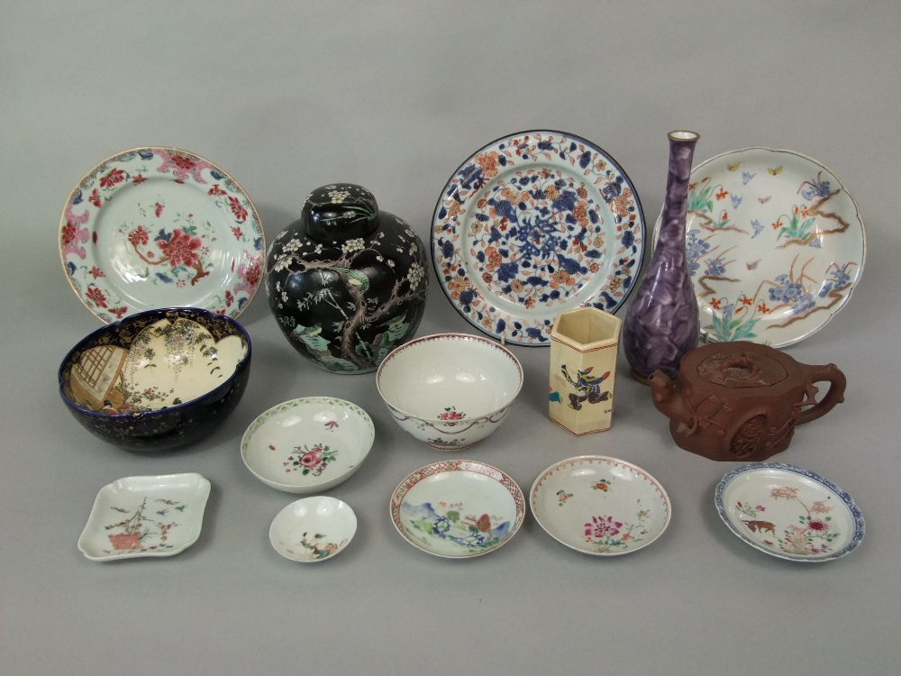 A collection of oriental ceramics including a black ground ginger jar and cover with prunus