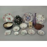 A collection of oriental ceramics including a black ground ginger jar and cover with prunus