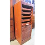 A teak floorstanding filing cabinet with rise and fall tambour door enclosing tray slides