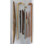 A mixed collection of walking canes, together with a large rosewood page turner and plaited