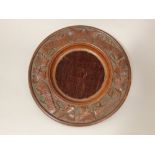 A Victorian carved oak offertory plate, circular with trailing vine leaf decoration, Southgate