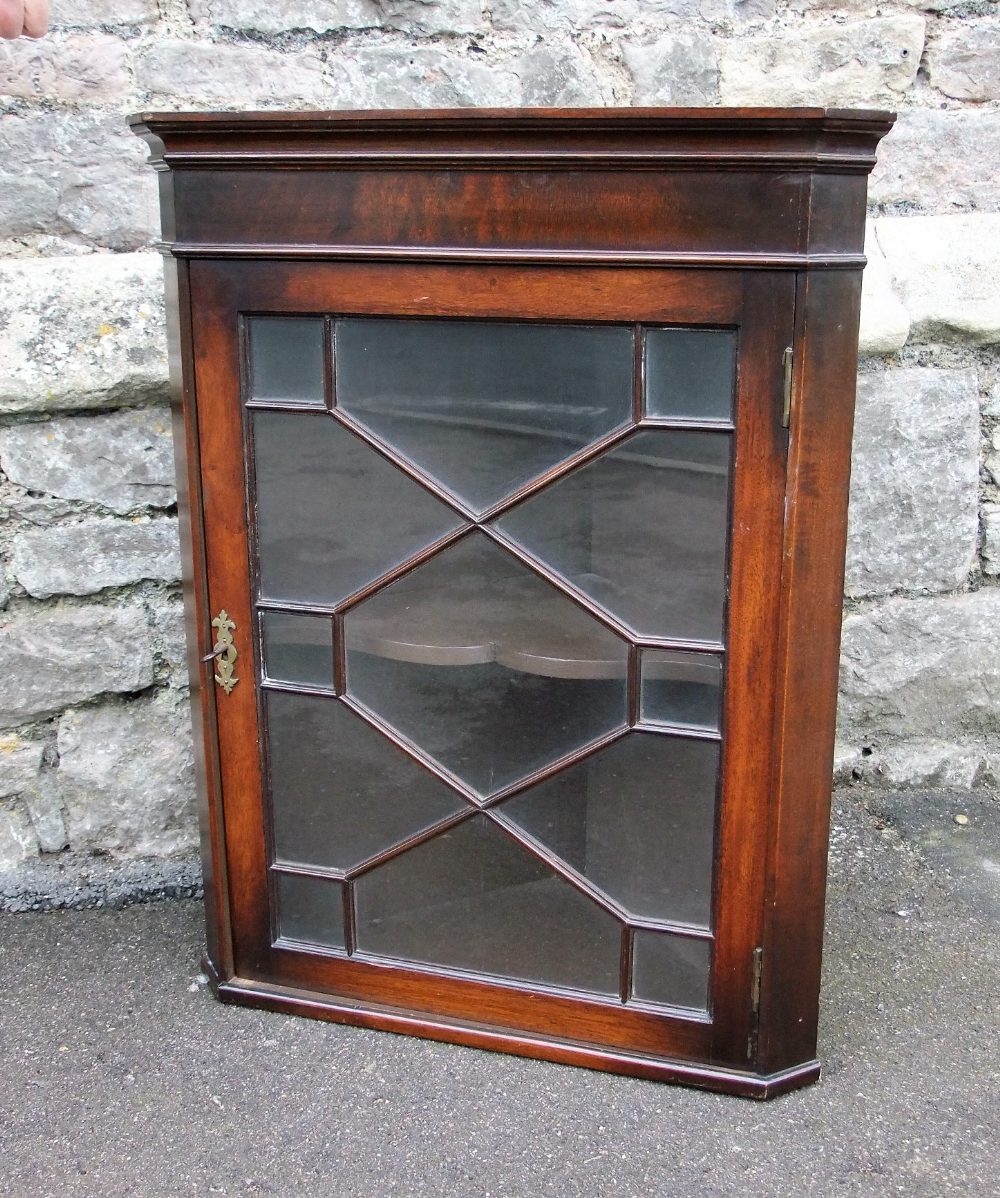 A small Edwardian mahogany cupboard with astragal glazed door