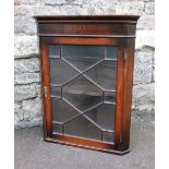 A small Edwardian mahogany cupboard with astragal glazed door