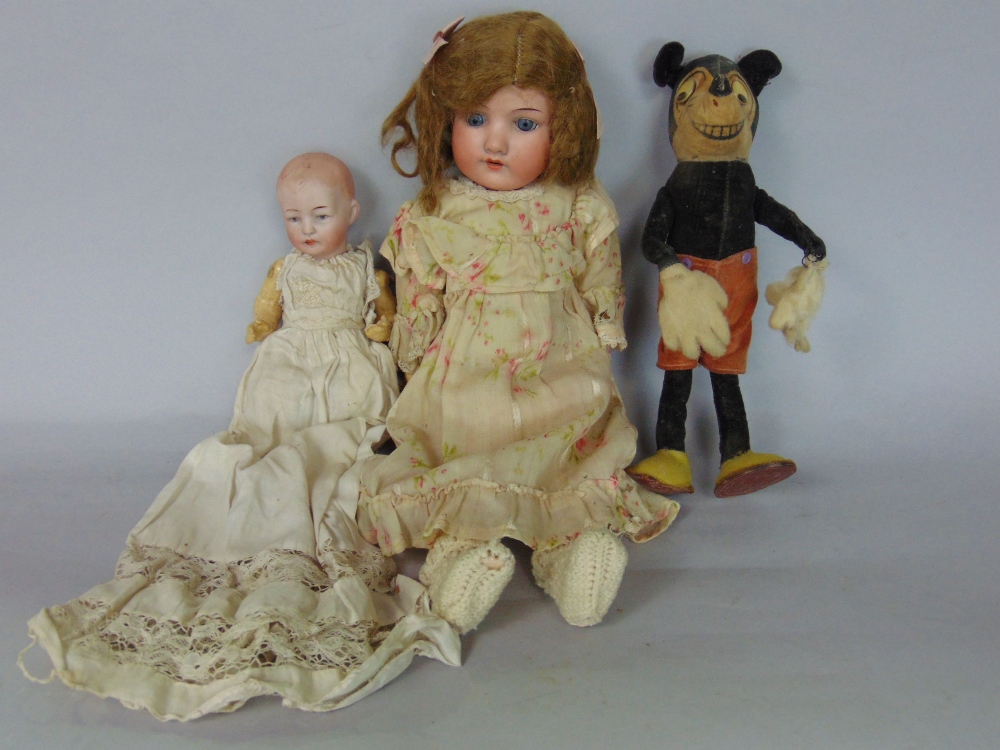 A vintage felt Mickey Mouse doll, 22cm high; together with a further bisque headed baby doll, with