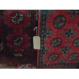 A near pair of small Persian wool rugs, each with multi medallion panels upon red/pink fields within