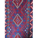 An eastern runner in a red and blue colourway with medallion centre within running borders, 265 x