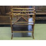 A late Victorian two divisional bamboo Canterbury with lacquered panels and swept supports