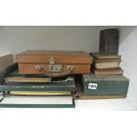 A small leather writing case in the form of a suitcase, a blue leather travelling picture frame,