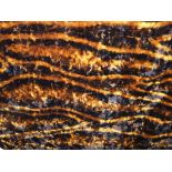 A vintage travel rug in abstract tiger skin striped finish, together with a vintage car foot warmer,