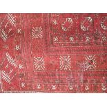 A Persian style wool rug in the Afghan manner with central white ground lozenge detail upon a red