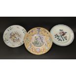 A collection of 19th century continental tin glazed earthenwares comprising a charger with painted