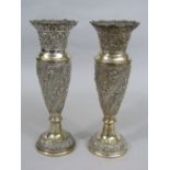 A pair of eastern white metal silver baluster vases, with embossed bands of birds and scrolled