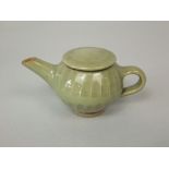 A small studio pottery teapot and cover with moulded detail and celadon type glaze and with