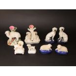 A pair of 19th century Staffordshire models of seated dalmatians raised on oval bases, 13 cm tall