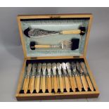 A good quality walnut canteen of various bone handled fish cutlery to include a fish serving knife