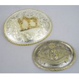 Two American white metal buckles, one mounted by a gilt metal character group of a man and a