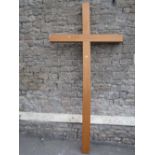 A large contemporary light oak crucifix 252 cm high x 126 cm